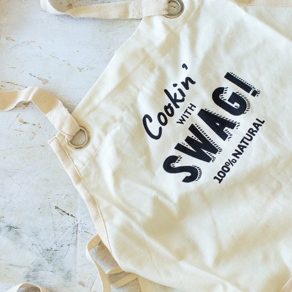 A gorgeous, beautifully hand made Swag apron made from unbleached unseeded cotton and featuring the slogan "Cookin' with Swag" - The Swag AU