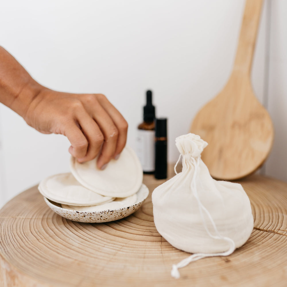 
                      
                        The Swag Beauty Swag Set on a wooden table with beauty products and oils whilst a hand reaches for one of the beauty rounds - The Swag AU
                      
                    