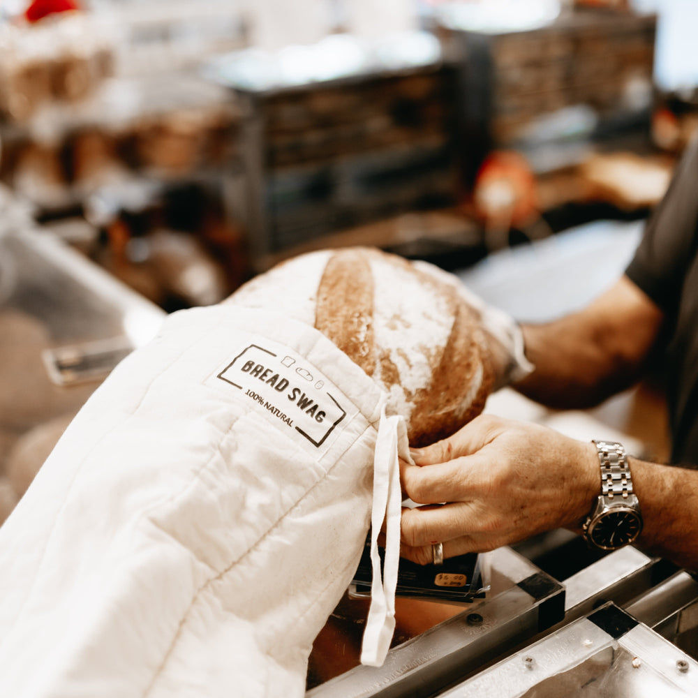 
                      
                        The Swag - a sourdough loaf being put into the reusable Bread Swag by the baker - The Swag AU
                      
                    