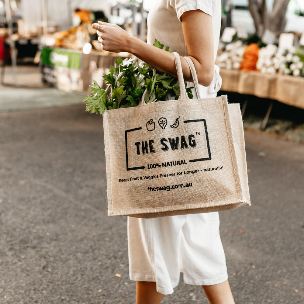 
                      
                        Woman at the shops holding The Swag reusable and 100% natural carry bags made from hessian and filled with fresh fruit and veggies - The Swag AU

                      
                    