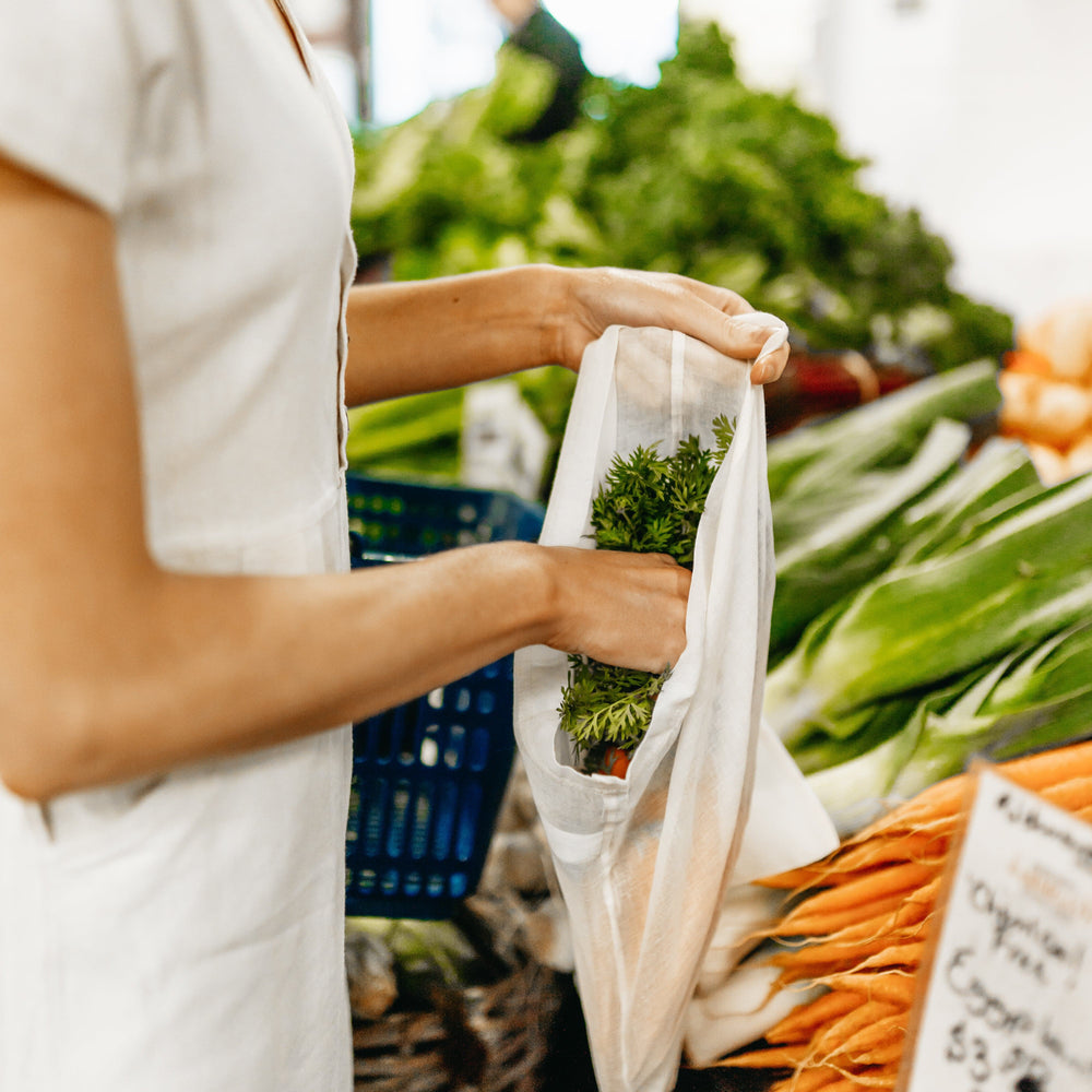
                      
                        The Swag with a lady at the shops putting baby carrots into the lightweight reusable produce bags - The Swag AU
                      
                    