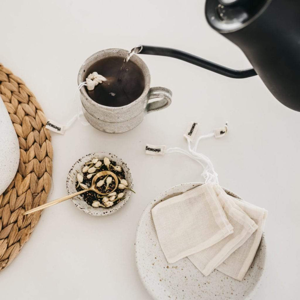 
                      
                        100% natural and reusable tea bag set with a cup of tea and one tea Swag dangling out of the cup - The Swag AU
                      
                    