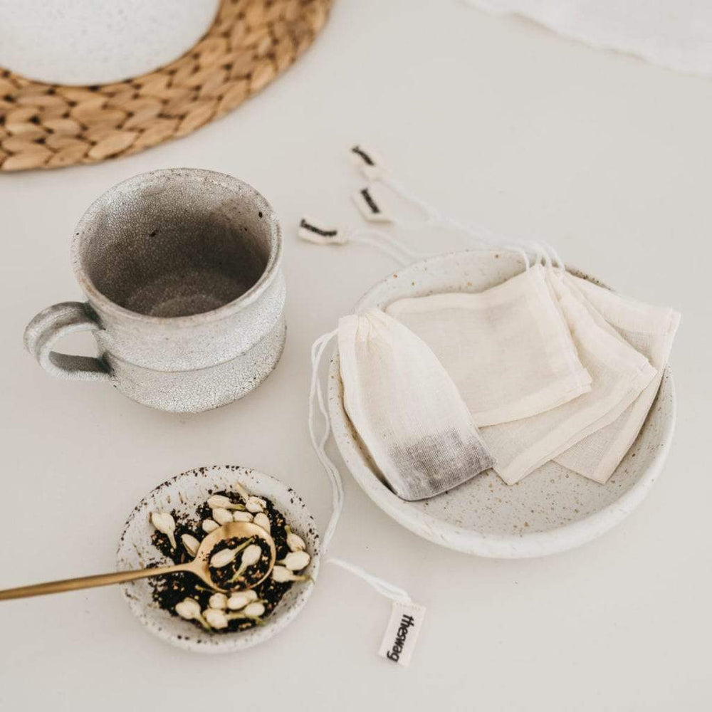 
                      
                        100% natural and reusable Tea bag set with a cup of tea and one tea Swag dangling out of the cup - The Swag AU
                      
                    