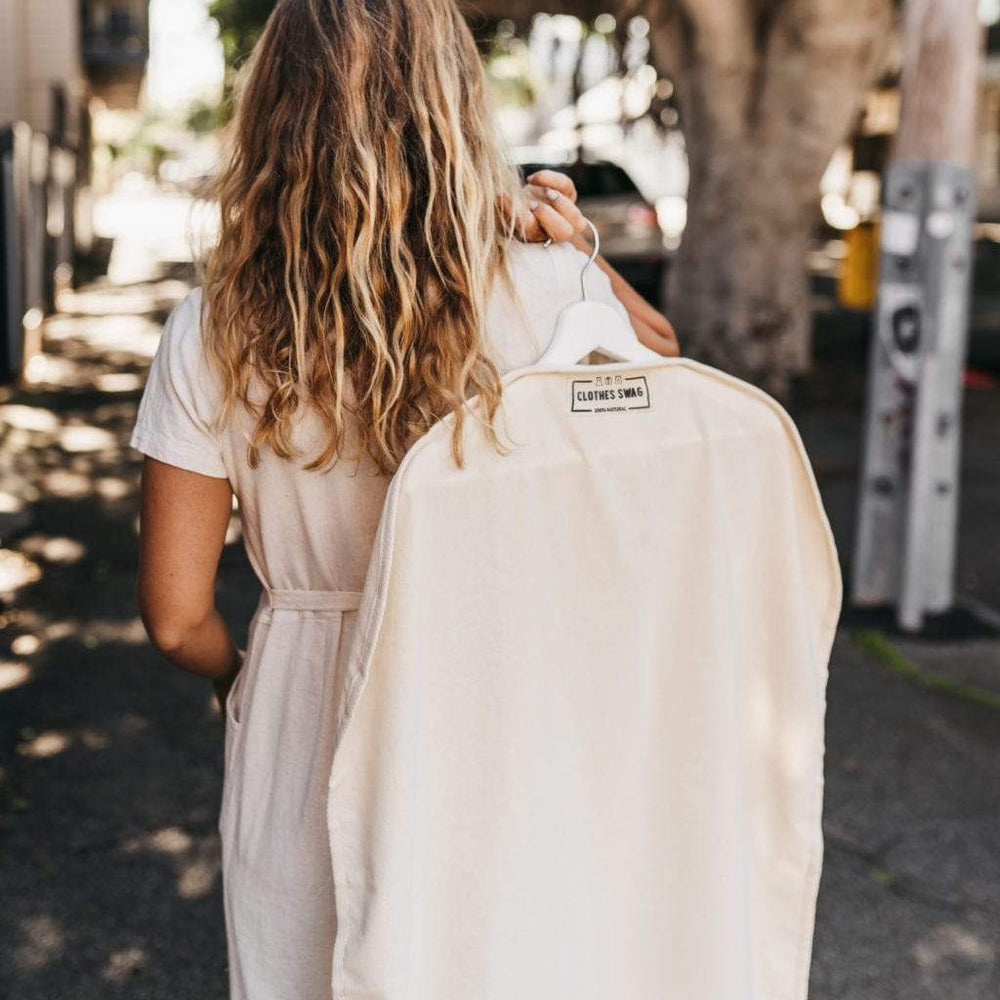
                      
                        The Swag  - a woman carrying her reusable Clothes Swag over her shoulder that is  filled with clothing on a hanger - The Swag AU 
                      
                    
