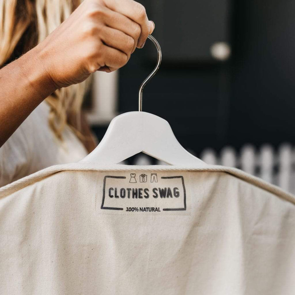 
                      
                        The Swag  - a woman holding The reusable Clothes Swag on a hanger while showing The Clothes Swag logo - The Swag AU
                      
                    