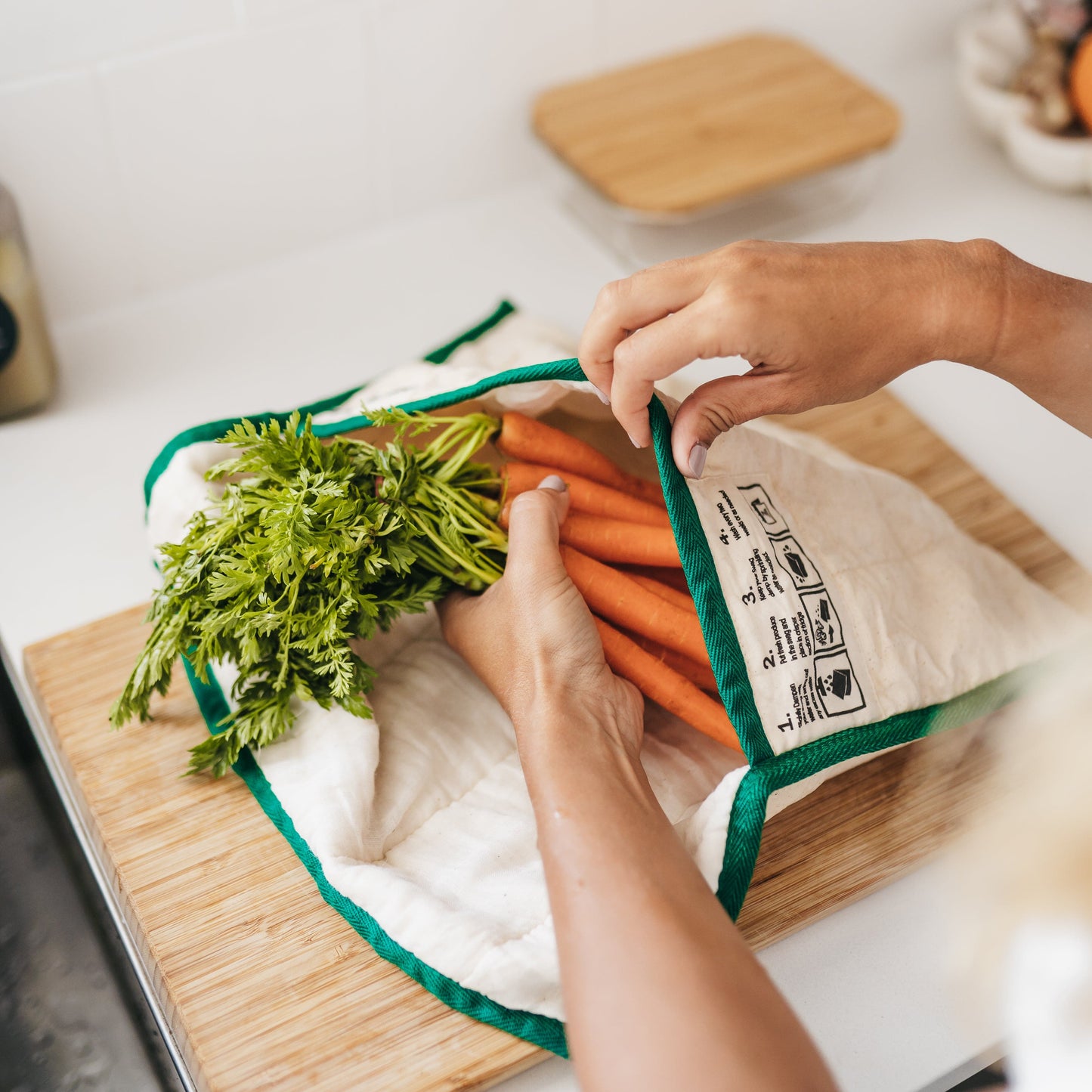 Small Reusable produce bag for the fridge showing hands putting baby carrots into The Swag bag - The Swag AU