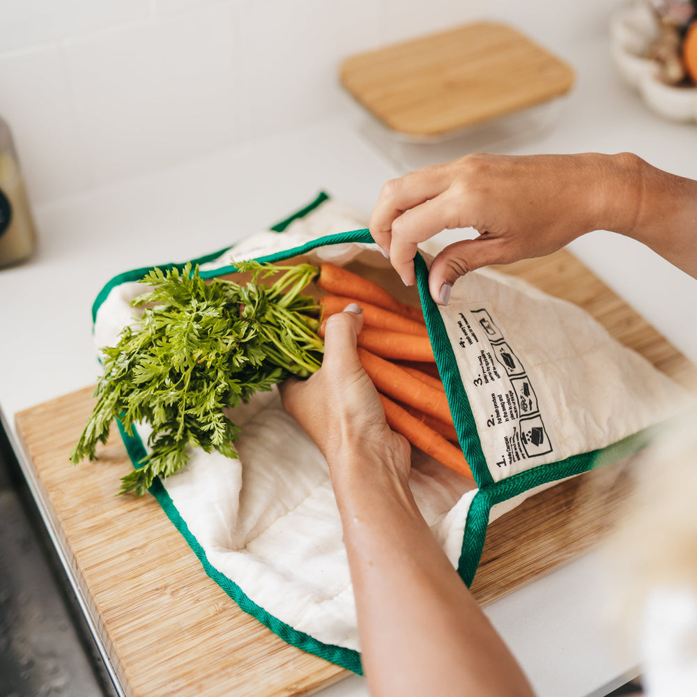 Small Reusable produce bag for the fridge showing hands putting baby carrots into The Swag bag - The Swag AU